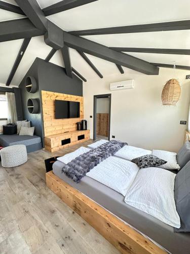 a bedroom with a large bed and a tv at Villa Sara in Lotzorai