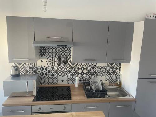 une cuisine avec des armoires blanches et un four à plaques de cuisson dans l'établissement Studio à deux pas de la plage, à Nice