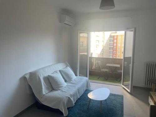 un salon avec un canapé blanc et une table dans l'établissement Studio à deux pas de la plage, à Nice