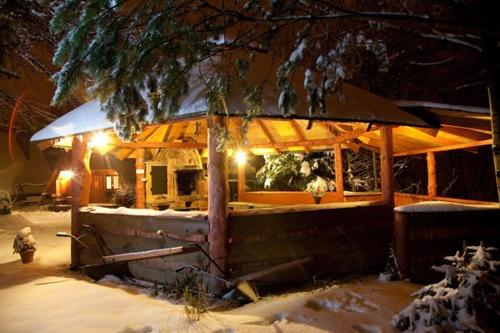a snow covered building with a lighted at Domki pod Skałką in Baligród