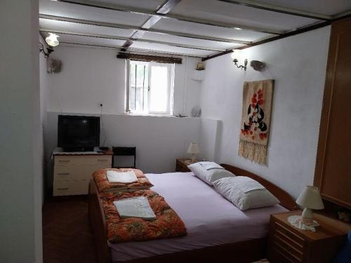 sypialnia z 2 łóżkami i telewizorem w obiekcie Art House Old Village w mieście Jesenice
