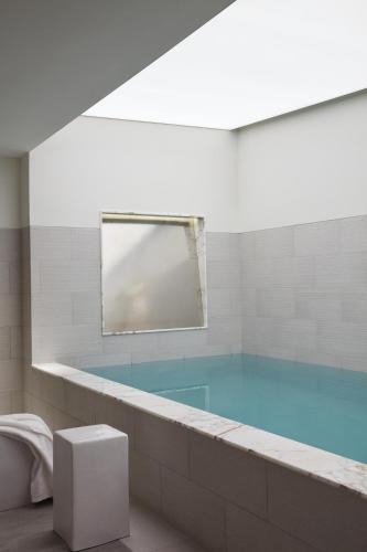 a bathroom with a large tub with a mirror at Hotel La Villa Saint Germain Des Prés in Paris