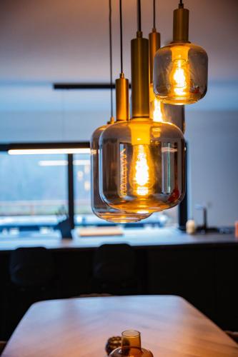 aendant light hanging over a wooden table at La villa M in Sart-lez-Spa