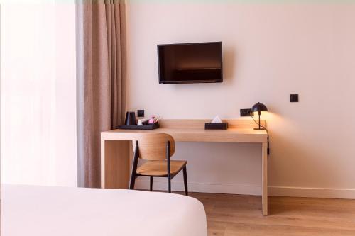 Cette chambre dispose d'un bureau et d'une télévision murale. dans l'établissement Grand Hôtel De La Seine, à Rouen