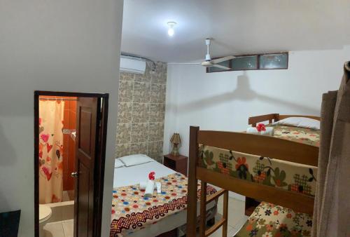 a small room with two bunk beds and a mirror at Hostal Casa Taisha in Montañita