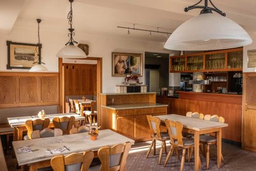 a restaurant with tables and chairs and a kitchen at Hotel-Restaurant Kelter in Esslingen
