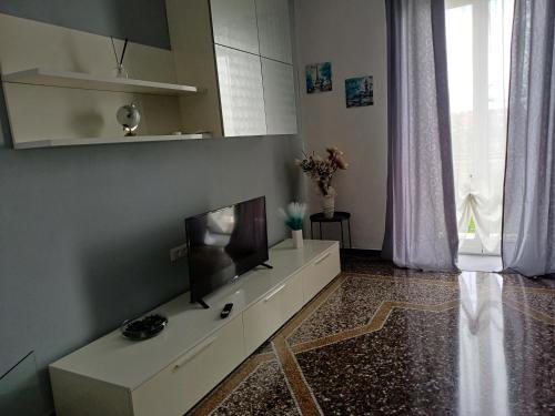 a living room with a television on a white cabinet at Casa Sole E Luna in Genova