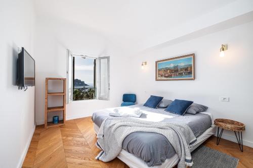 une chambre blanche avec un lit et une télévision dans l'établissement FEEL HOME - VISTA Di PORTU, à Nice