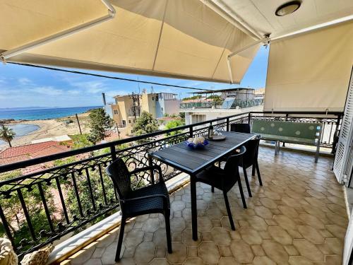 a table and chairs on a balcony with a view of the ocean at Bratis House Arkoudi in Arkoudi