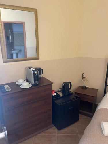 um quarto com uma cama e uma cómoda com um micro-ondas em Bed and Relax-Il Maniero em Calatabiano