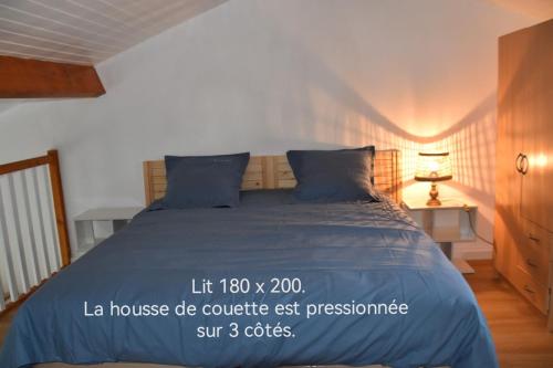 - un lit avec une couette bleue dans l'établissement La cigogne, à La Tremblade