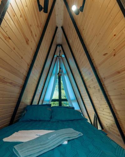 a bed in a wooden room with a window at Paradise Keda in Keda