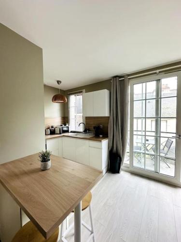 une cuisine avec une table en bois et une grande fenêtre dans l'établissement Les Halles - Hypercentre, à Dijon