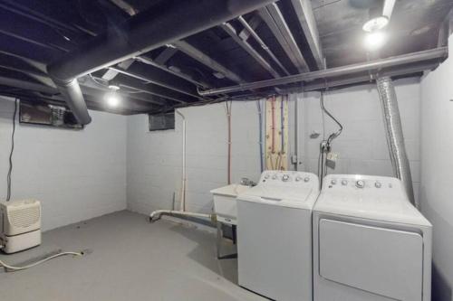 a laundry room with two washing machines in it at The Playmakers Funhouse-HOF Village in Canton