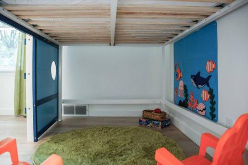 a childs room with blue walls and orange chairs at The Playmakers Funhouse-HOF Village in Canton