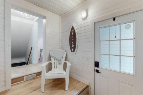 a white room with a white chair and a mirror at The Playmakers Funhouse-HOF Village in Canton