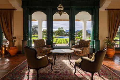 a living room with chairs and a table and a large window at Patios de Cafayate - Wine Hotel & Restaurant in Cafayate
