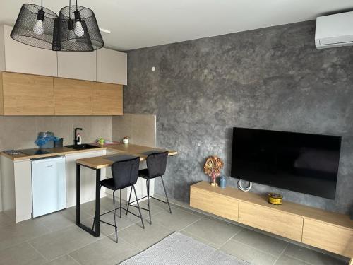 eine Küche mit einem Tisch und einem TV an der Wand in der Unterkunft Apartment Niš in Niš