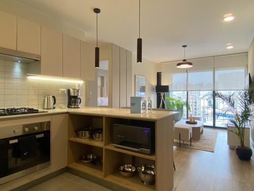 a kitchen with white cabinets and a living room at Pod by Wynwood House in Lima
