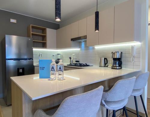 a kitchen with white counter tops and blue chairs at Pod by Wynwood House in Lima