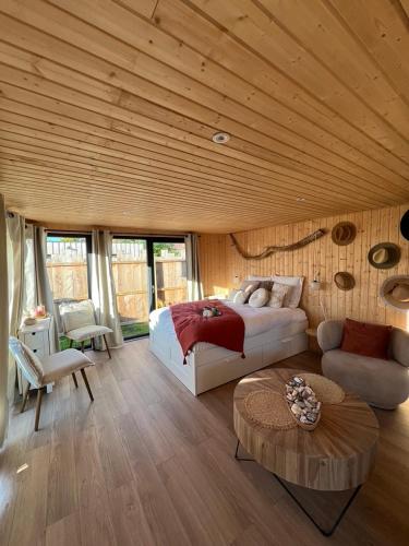 une chambre avec un lit et une table dans une pièce dans l'établissement Le coquillage, la clef des paons, à Luc-sur-Mer