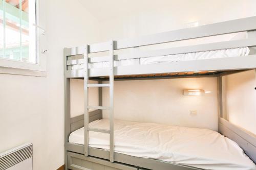 Ce lit superposé se trouve dans une petite chambre située dans une maison. dans l'établissement Les Appartements aux Restanques du Golfe de St Tropez - maeva Home - Appartement 2 pièces coin cabine 7 personnes - Sélection - vue Mer MAE-3148, à Grimaud