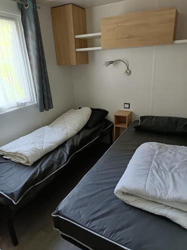 une chambre avec deux lits et une fenêtre dans l'établissement MH 329 Camping Bois Dormant, à Saint-Jean-de-Monts