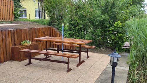 a picnic table and a bench next to a fence at Dunaparti vendégház in Ráckeve