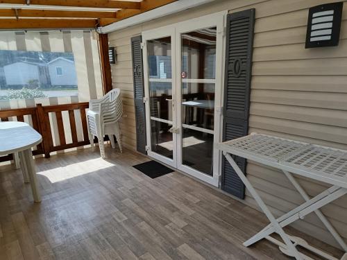 une terrasse couverte avec une table et des chaises sur une maison dans l'établissement MH 329 Camping Bois Dormant, à Saint-Jean-de-Monts