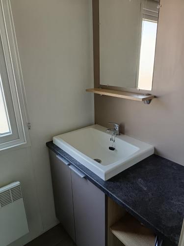 une salle de bain avec un lavabo blanc et un miroir dans l'établissement MH 329 Camping Bois Dormant, à Saint-Jean-de-Monts