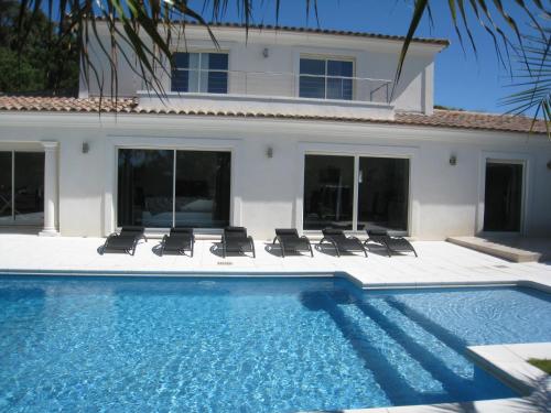 une piscine avec des chaises et une maison dans l'établissement Villa Aureliana, à Saint-Raphaël
