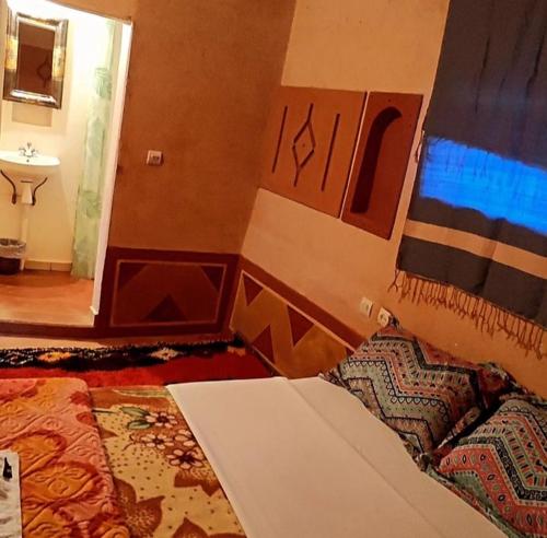 1 dormitorio con 1 cama y lavamanos en una habitación en Gorges View Dades, en Tamellalt