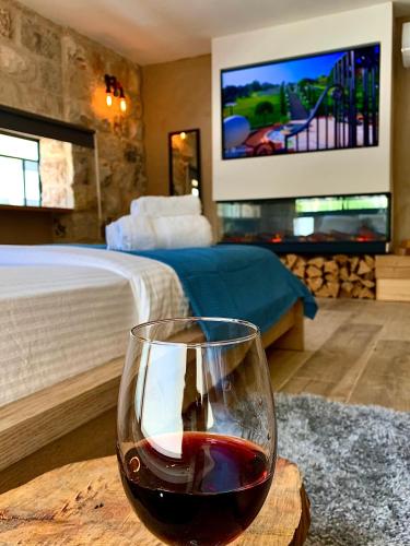 a glass of wine sitting on a table in a bedroom at Boutique apartment in heart of Haifa in Haifa