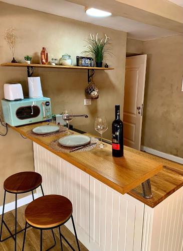 a kitchen with a counter with a microwave and two stools at Boutique apartment in heart of Haifa in Haifa