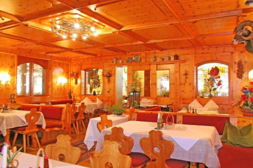 a restaurant with tables and chairs and a chandelier at Hotel Kajetansbrücke in Pfunds