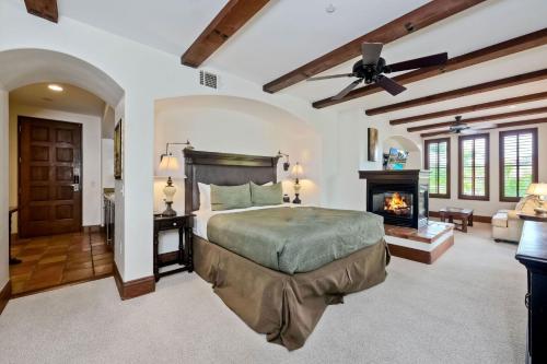 a bedroom with a bed and a fireplace at Heated Pool & Hot Tub Access, Walk 2 Omni Resort, Free Parking, Wi-Fi, Washer & Dryer in Encinitas