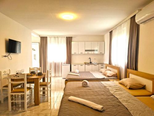 a room with two beds and a table and a kitchen at IVANA Apartments in Ulcinj