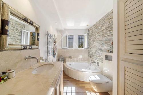 une salle de bain avec une baignoire, un lavabo et des toilettes dans l'établissement Villa Ganesh, à Le Rouret