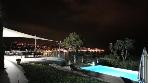 - une piscine de nuit avec une ville en arrière-plan dans l'établissement Unique ! Villa plain-pied vue exceptionnelle golfe St Tropez à 200 m de la plage, à Sainte-Maxime