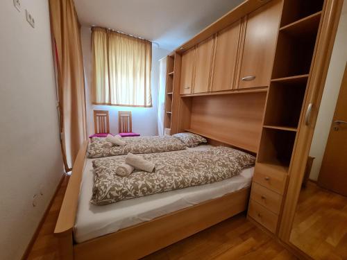 a small bedroom with a bed and a wooden cabinet at Haus Lilly by Globalimmoservice in Bad Kleinkirchheim