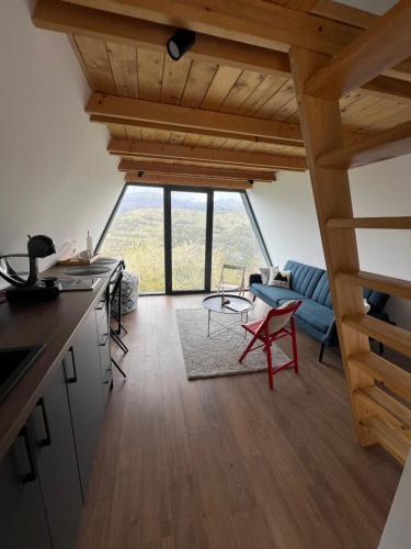 Una cocina y un salón con un gran ventanal. en Kucica na Brdu, en Brda