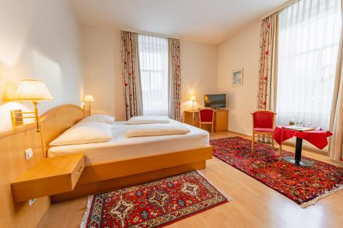 - une chambre avec un grand lit et un tapis rouge dans l'établissement Postwirt, à Seeboden