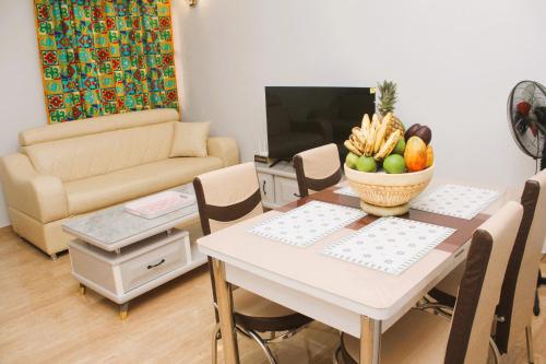 a living room with a table with a bowl of fruit at Résidence la Détente AKF-Adidogomé in Lomé