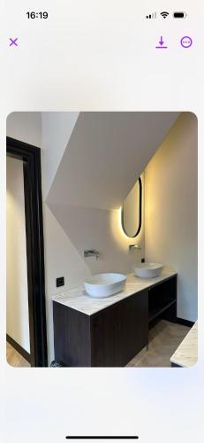 a bathroom with two sinks and a mirror at Hotel Restaurant Het Witte Paard in Delden