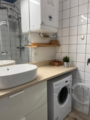 a bathroom with a sink and a washing machine at Darba 2 in Darłowo