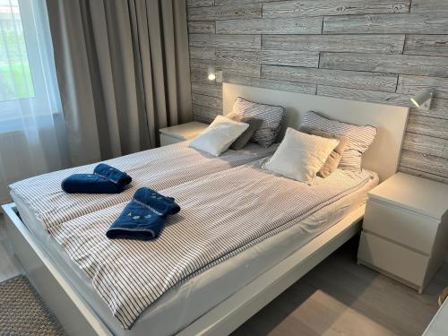 a bed with two blue towels on top of it at Darba 2 in Darłowo