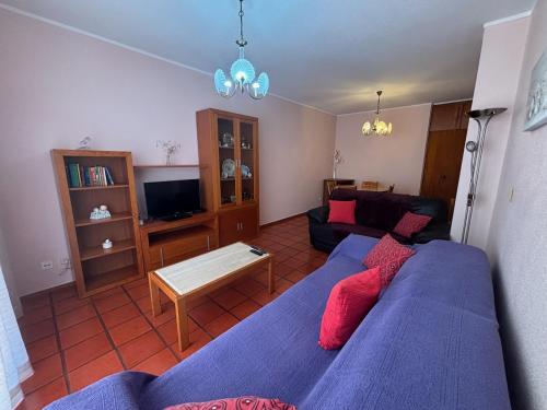 a living room with a blue bed and a couch at Rosário - two bedroom apart- Buarcos - Figueira da Foz in Figueira da Foz