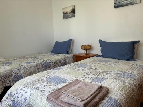 two beds sitting next to each other in a bedroom at Rosário - two bedroom apart- Buarcos - Figueira da Foz in Figueira da Foz