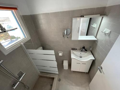 La petite salle de bains est pourvue d'un lavabo et d'un miroir. dans l'établissement ANCHOR, à Provatas
