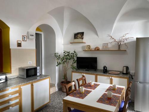 a kitchen with a table and a kitchen with a refrigerator at Casa Ginny in Ospedaletti